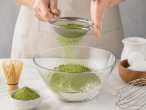 Matcha powder sifting into bowl showing preparation process for smooth texture